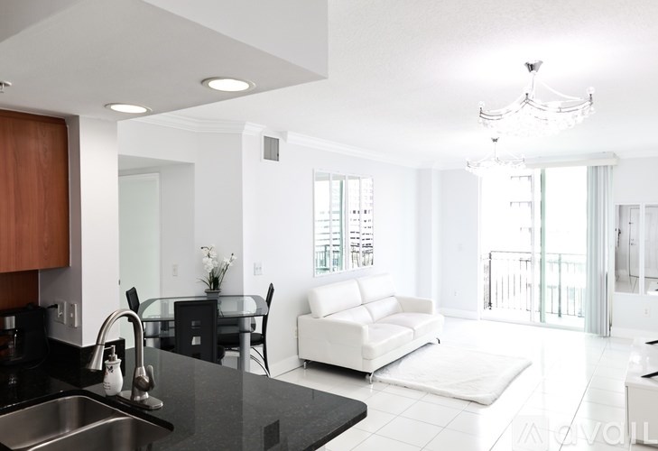 A modern kitchen with a black countertop and white appliances.