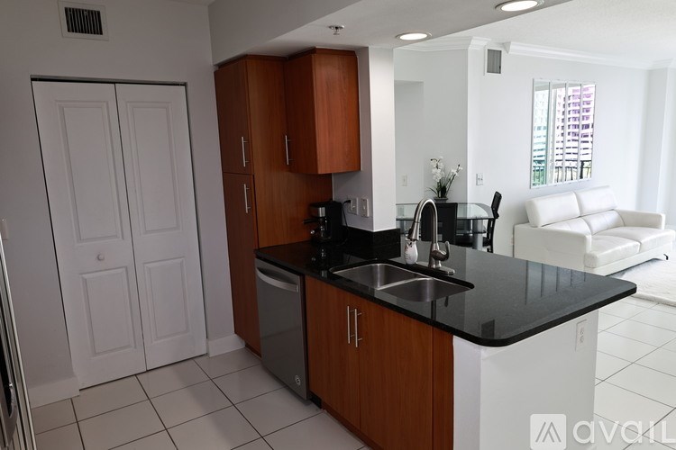 A kitchen with white appliances and a black countertop.