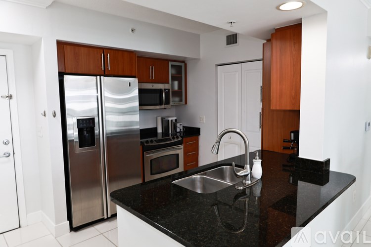 A kitchen with a black countertop and stainless steel appliances.