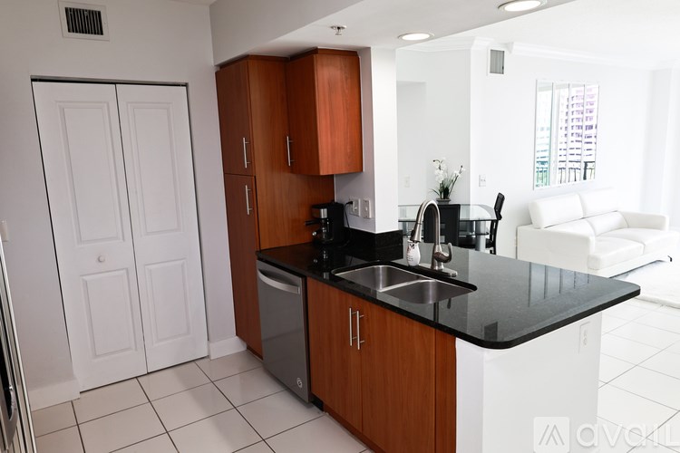 A kitchen with white appliances and a black counter top.