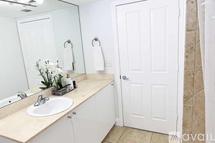 A bathroom with a sink, mirror, and towel rack.