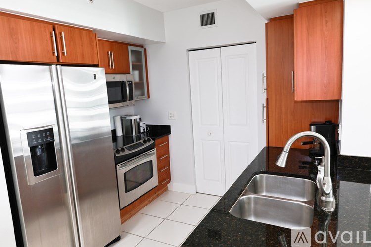 A kitchen with a stainless steel refrigerator, microwave, oven, and sink.