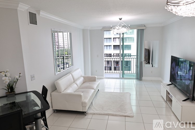 A living room with a white couch and a television.