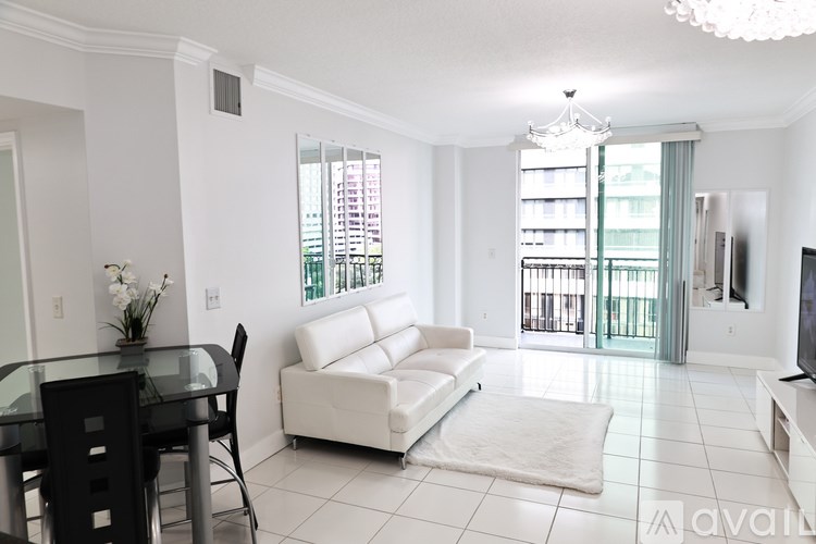 A living room with a glass table and white sofa.