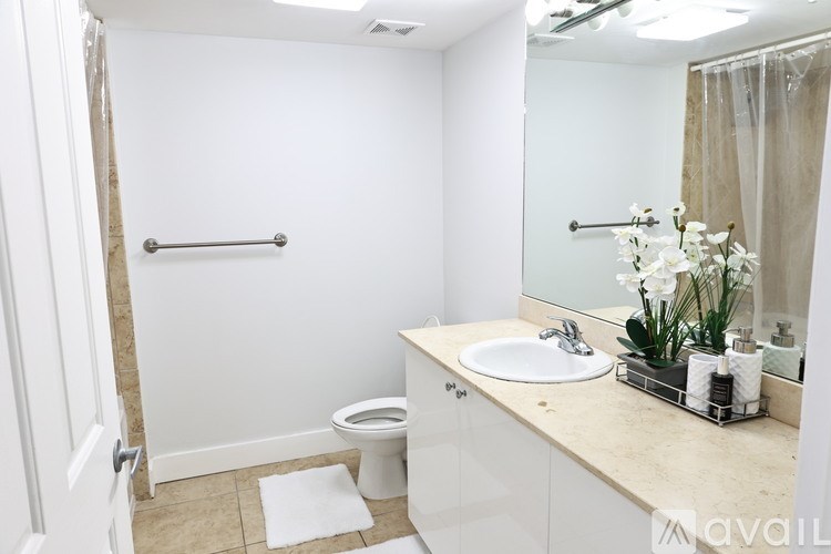 A bathroom with a toilet, sink, and mirror.