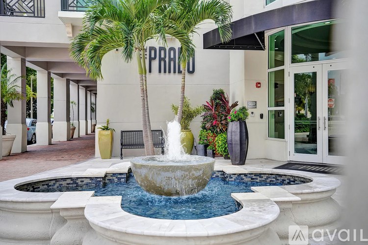A fountain in the middle of a courtyard with a palm tree and a sign that says "PRA".