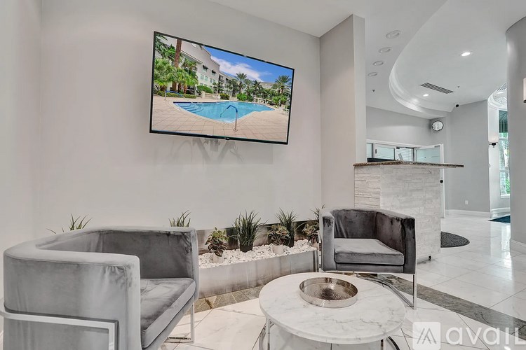 A modern living room with a television displaying a poolside scene.