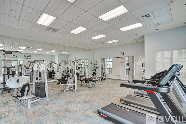 A gym with treadmills, weights, and exercise equipment.