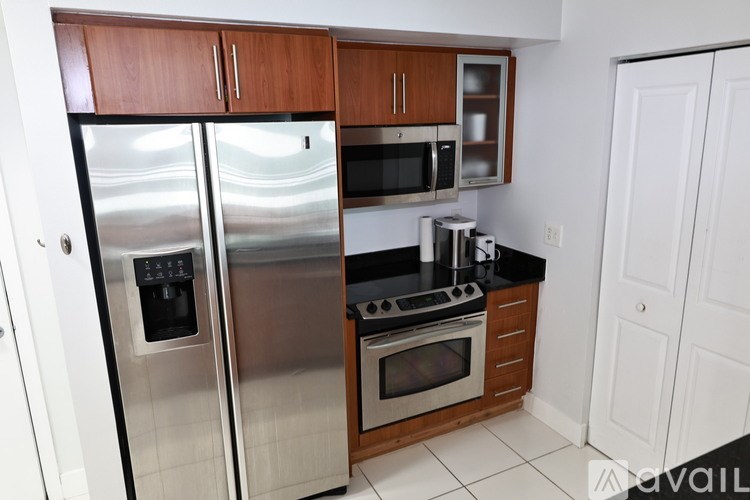 A kitchen with a stainless steel refrigerator, microwave, and oven.