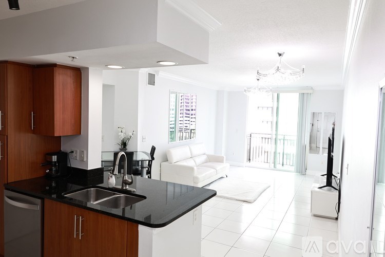 A modern kitchen with a black countertop and white appliances.