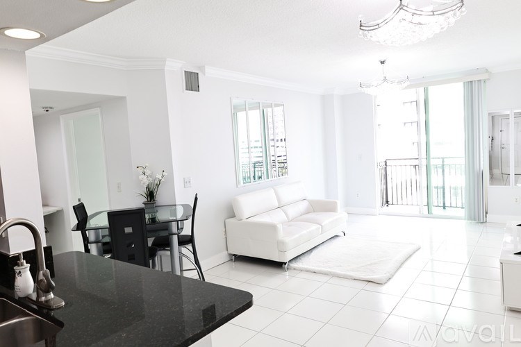 A modern kitchen with a black countertop and white appliances.