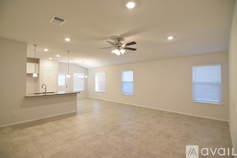 A spacious room with a ceiling fan and tiled flooring.