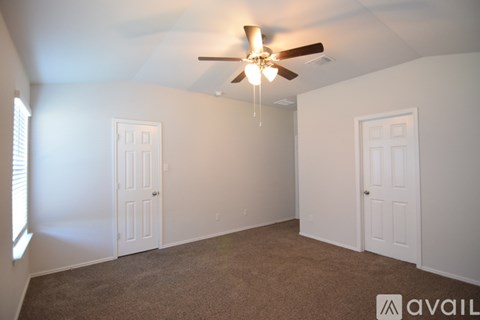 A room with a ceiling fan and two doors.