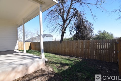 A house with a white porch and a wooden fence.
