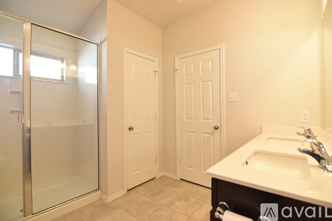 A bathroom with a sink, mirror, and shower.