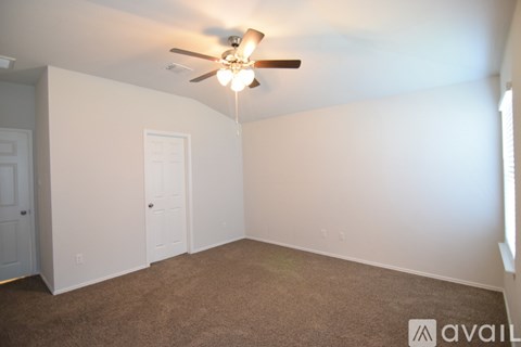 A room with a ceiling fan and carpeted floor.