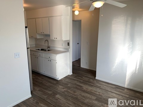 A kitchen with white cabinets and a sink.