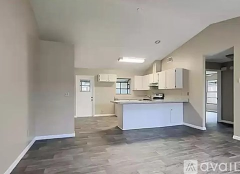 A spacious kitchen with white cabinets and a central island.
