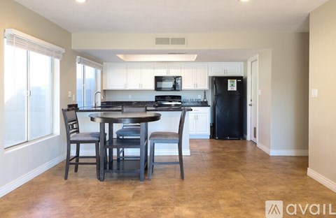 A kitchen with a table and chairs in the foreground.