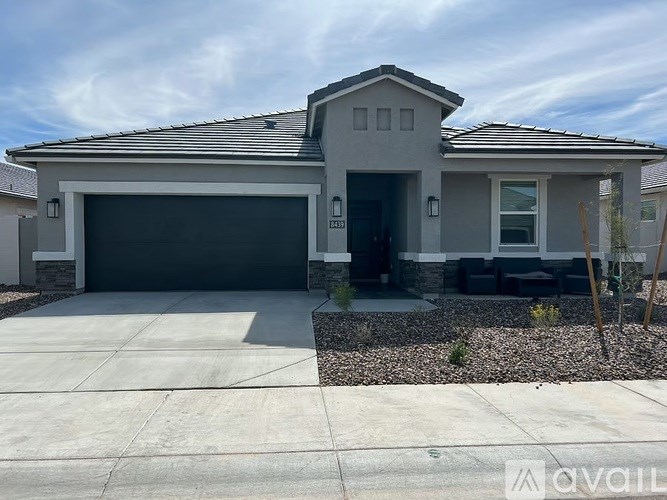 A modern house with a grey garage door and a black roof.
