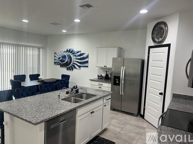 A modern kitchen with a large island and stainless steel appliances.