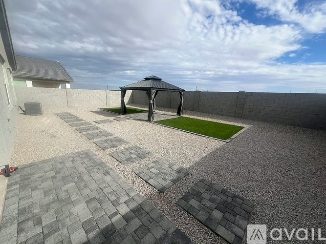 A patio with a black umbrella and grey paving stones.