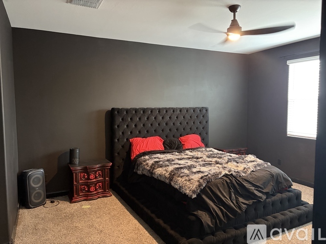 A bedroom with a bed, a television, and a chair.