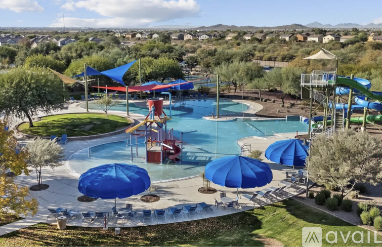 A large outdoor pool with a slide and a waterfall.