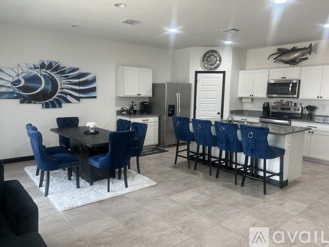 A modern kitchen with blue chairs and a dining table.
