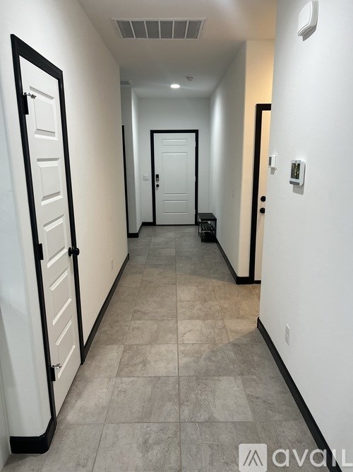 A hallway with a tiled floor and white walls.