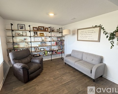 A living room with a brown leather chair and a grey sofa.