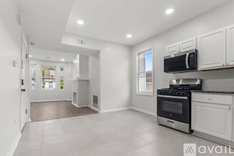 A kitchen with white cabinets and a stainless steel oven.