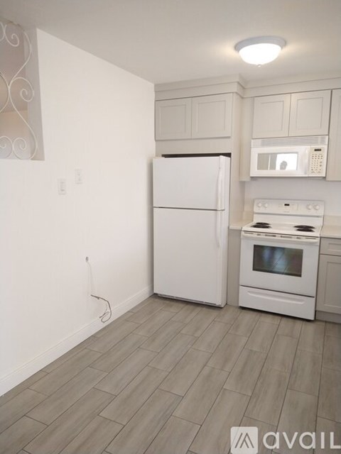 A kitchen with a white fridge and stove top oven.