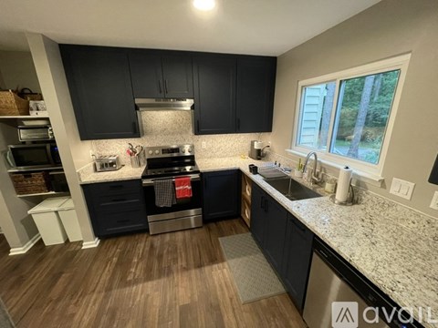 A kitchen with black cabinets and a stove top oven.