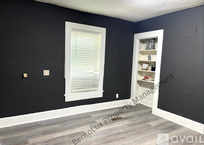 A room with a window and a shelf in it.
