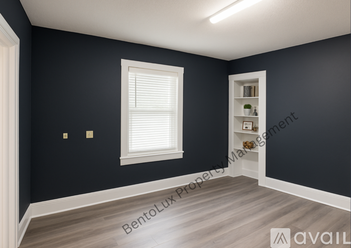 A room with dark walls and a window with blinds.