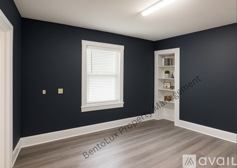 A room with dark walls and a window with blinds.