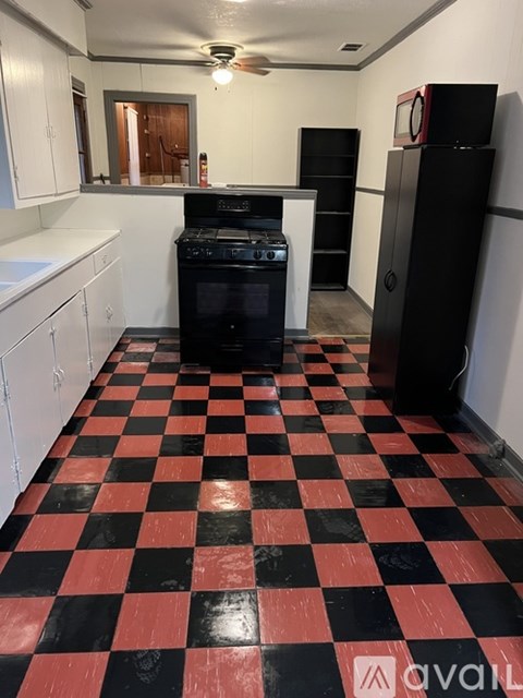 A kitchen with black and red checkered floor.