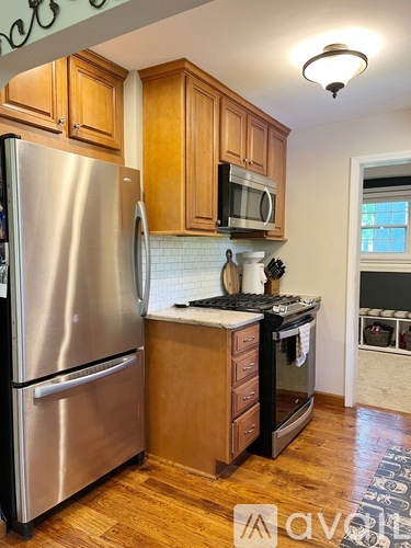 A kitchen with wooden cabinets and a stainless steel refrigerator.