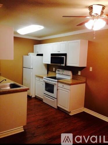 A kitchen with white appliances and wooden cabinets.