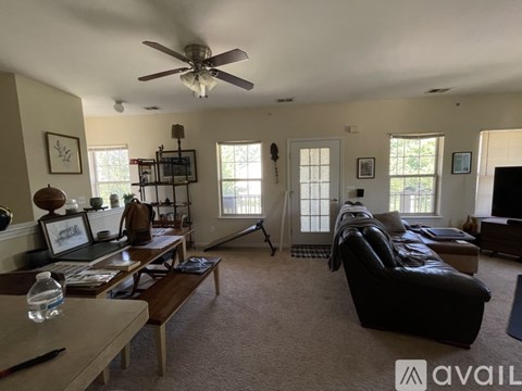 A living room with a black leather couch and a wooden coffee table.