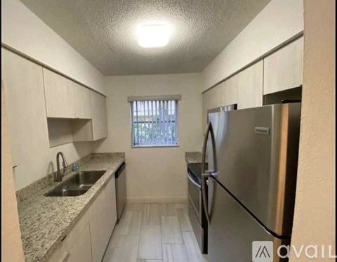A kitchen with a granite countertop and stainless steel appliances.