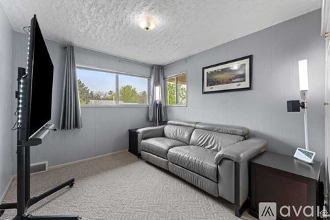A living room with a grey sofa and a television on a stand.