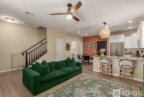 A living room with a green couch and a rug.