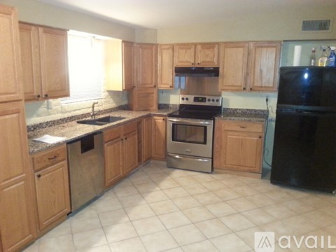 A kitchen with wooden cabinets and black appliances.