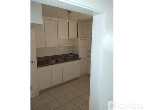 A kitchen with white cabinets and a brown countertop.