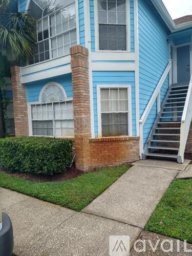 A blue house with a white staircase leading to the front door.