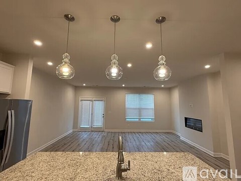A living room with a refrigerator on the left side and a television on the wall.