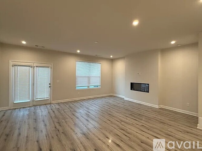 A spacious room with wooden flooring and a flat-screen TV mounted on the wall.