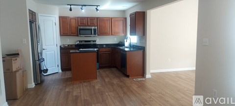 A kitchen with wooden cabinets and a black countertop.